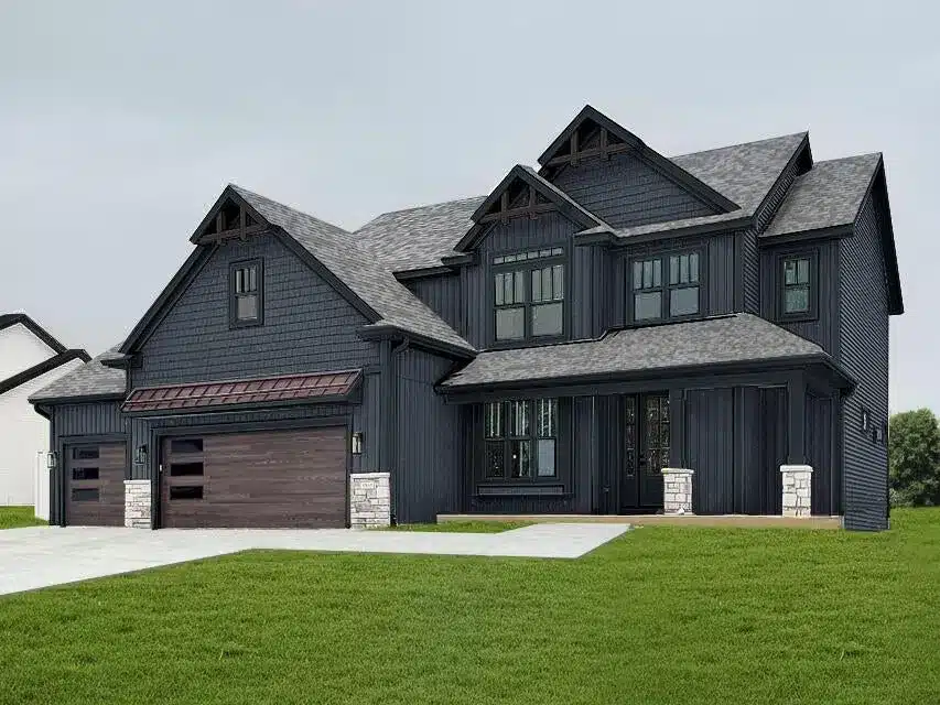 A modern two-story house with dark siding, large windows, a three-car garage, and a spacious green lawn in front.