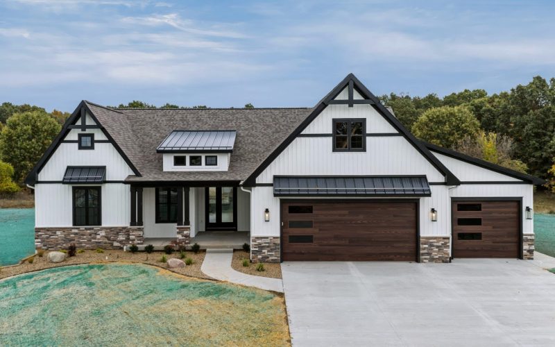 Front of the white farmhouse-style ranch at 8050 W PQ Ave with stone accents and a three-car garage.